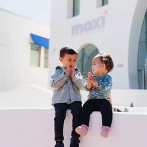 Toddlers sitting outside MOXI.