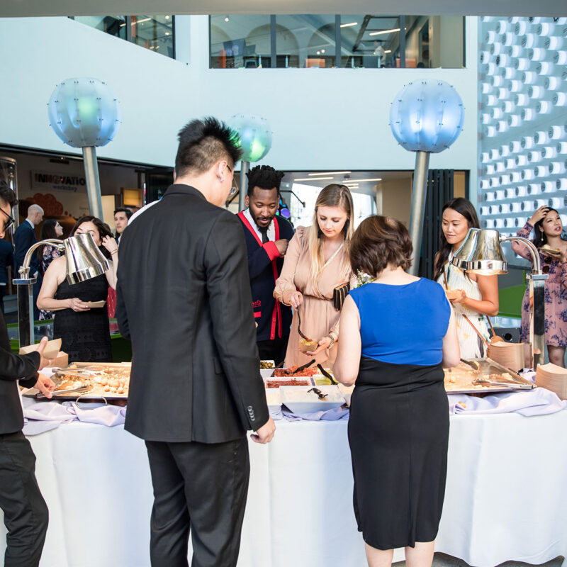 Fantastic-Forces-Courtyard---guests-with-food---DJ-California-Catering---Vicencio-Nguyen-Wedding